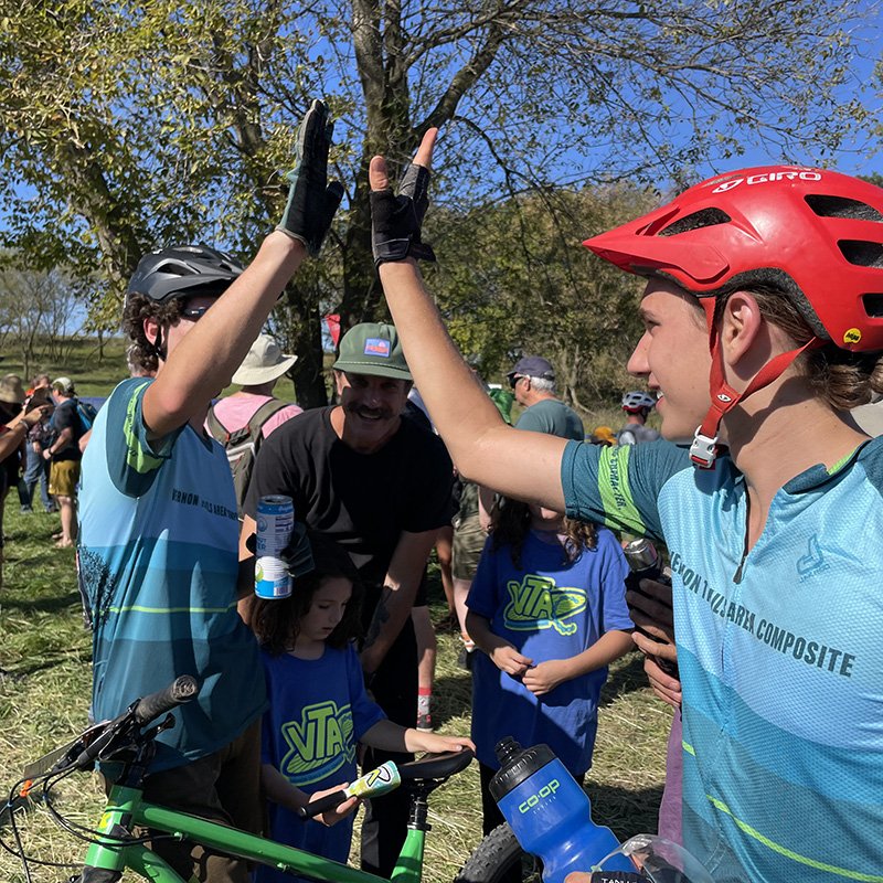 Youth Mountain Bike Riders giving each other a high five